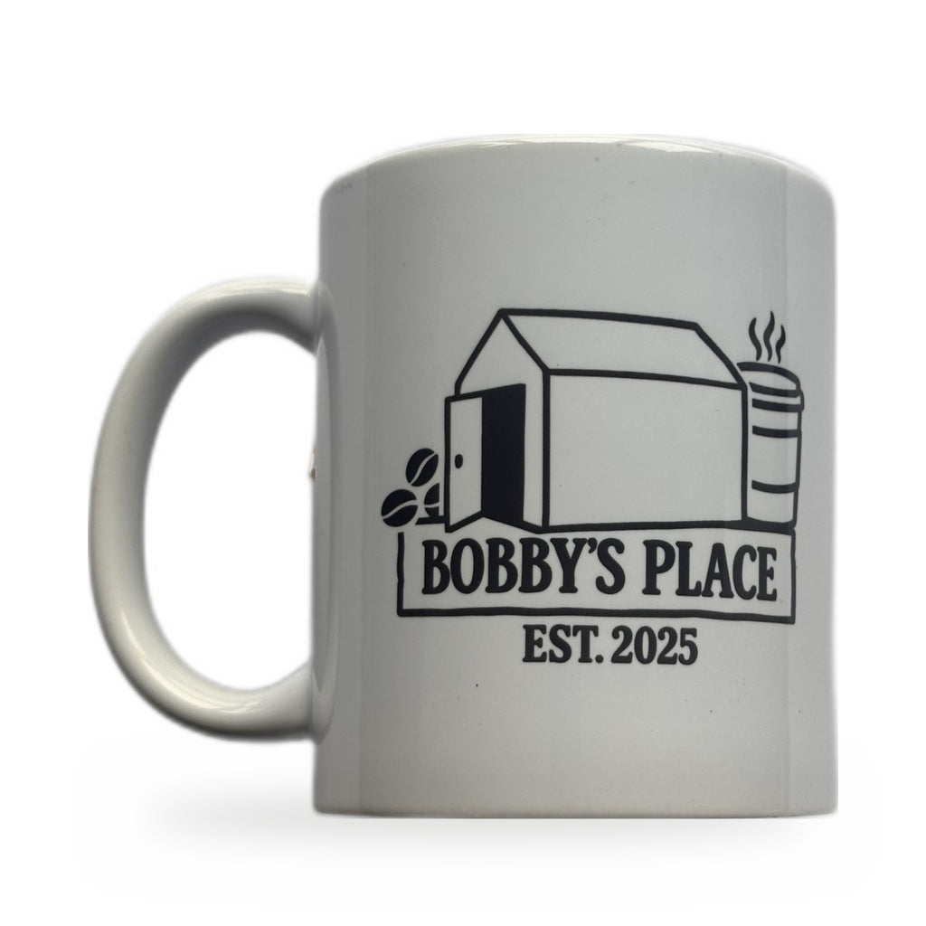 Bobby's Place mug — white ceramic mug with Bobby's Place Est. 2025 design