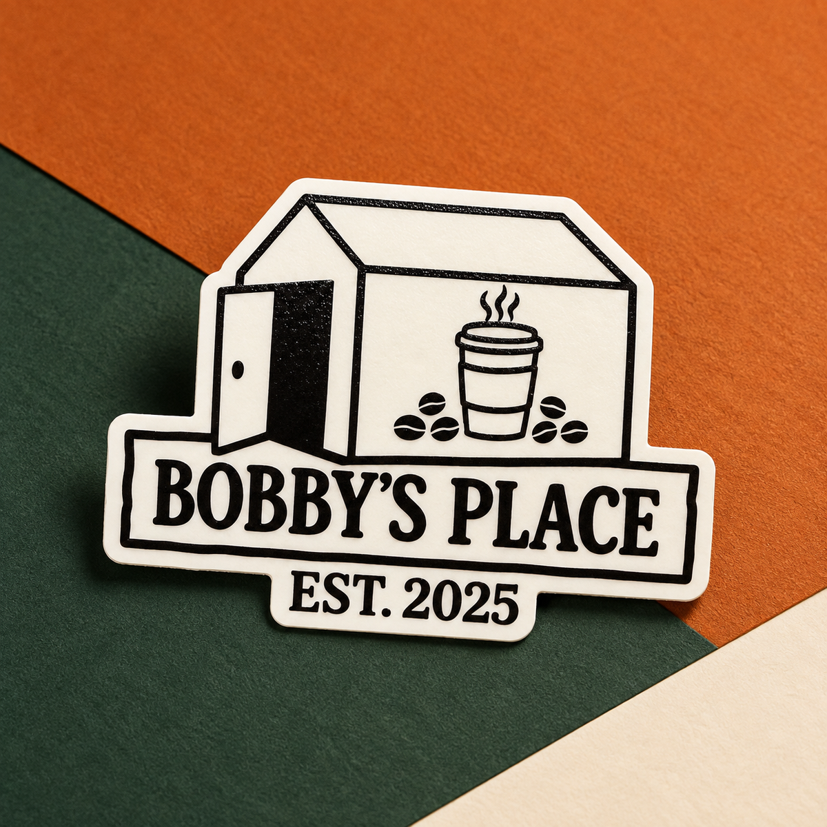 Bobby's Place glow in the dark sticker on Bobby's Beans orange, green and cream background