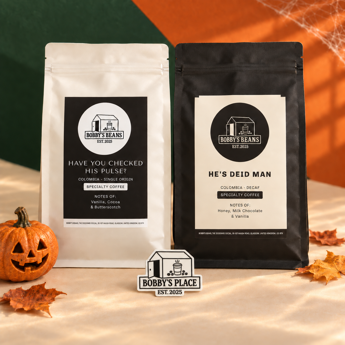The Deid Slug Halloween bundle with Have You Checked His Pulse? and He's Deid Man coffee bags beside a carved pumpkin and autumn leaves on a warm beige surface. Includes a Bobby's Place glow in the dark sticker.